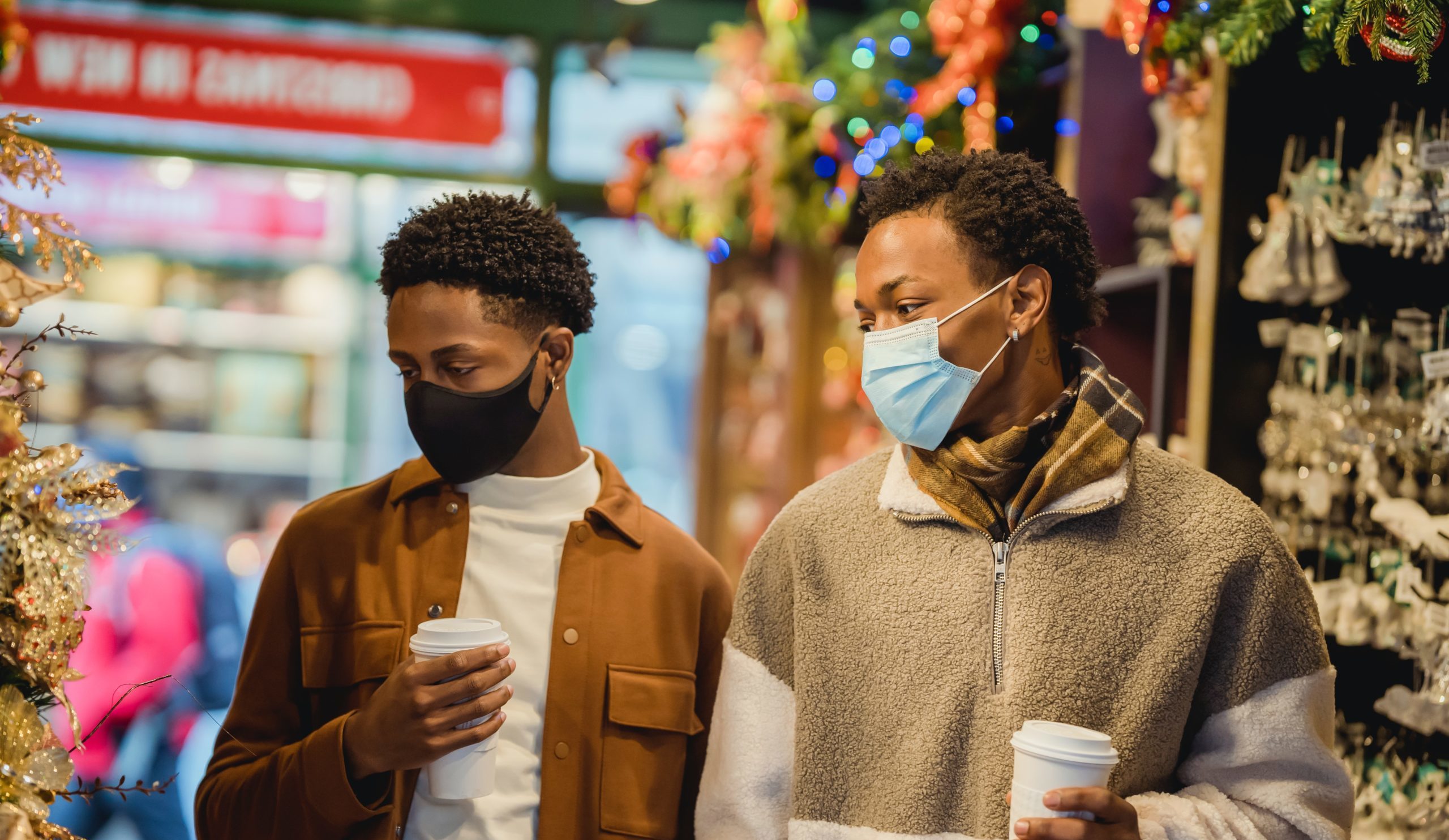 Two men holiday with face masks on shopping in store